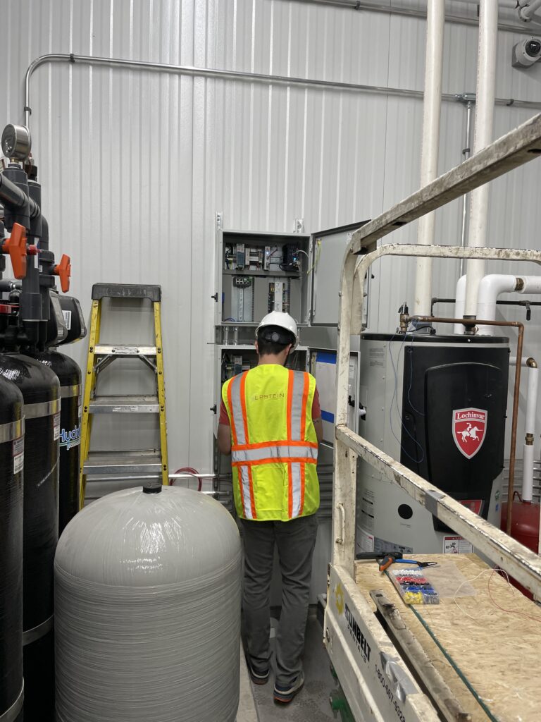 Technician testing a control panel during commissioning of a commercial water treatment system